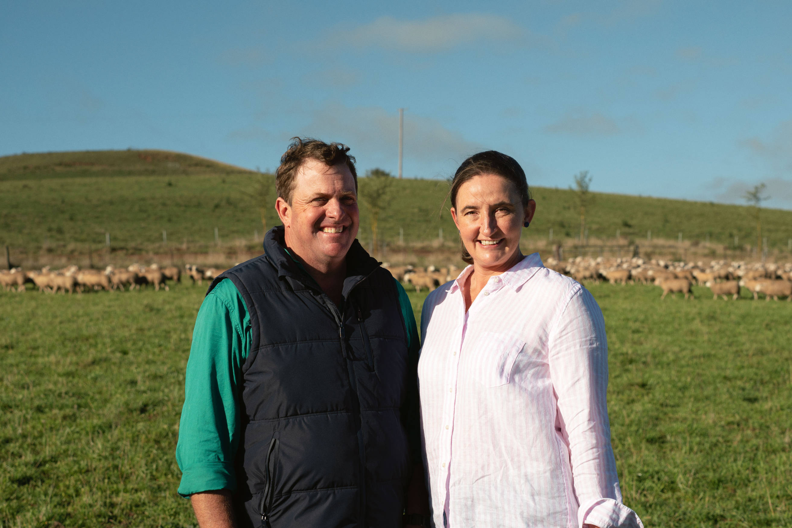 Two farmers standing outside in a field.